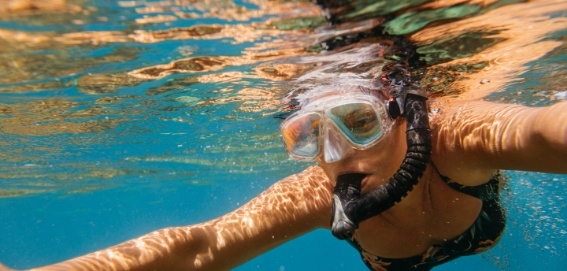 Woman in blue water snorkeling