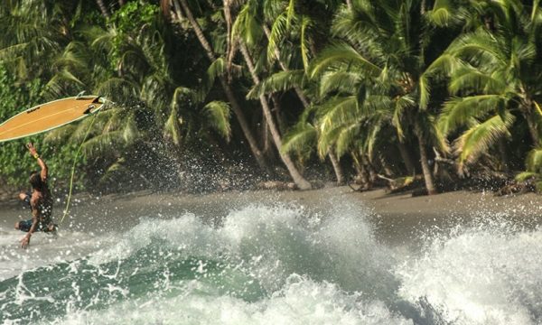 man with yellow board surfing