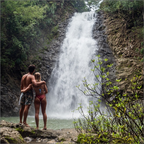 couple hug while looking at Montezuma Waterfall